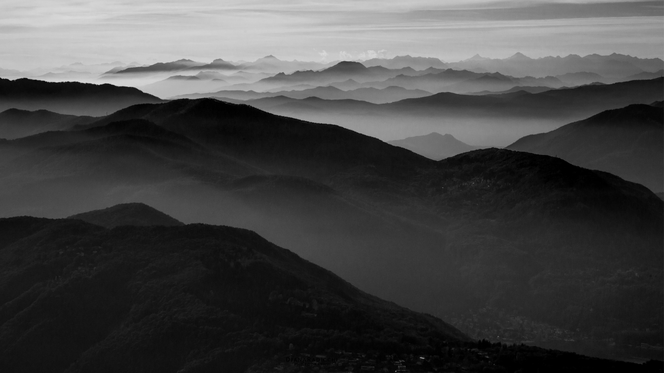 Black and white image of a series of mountains layered in the distance